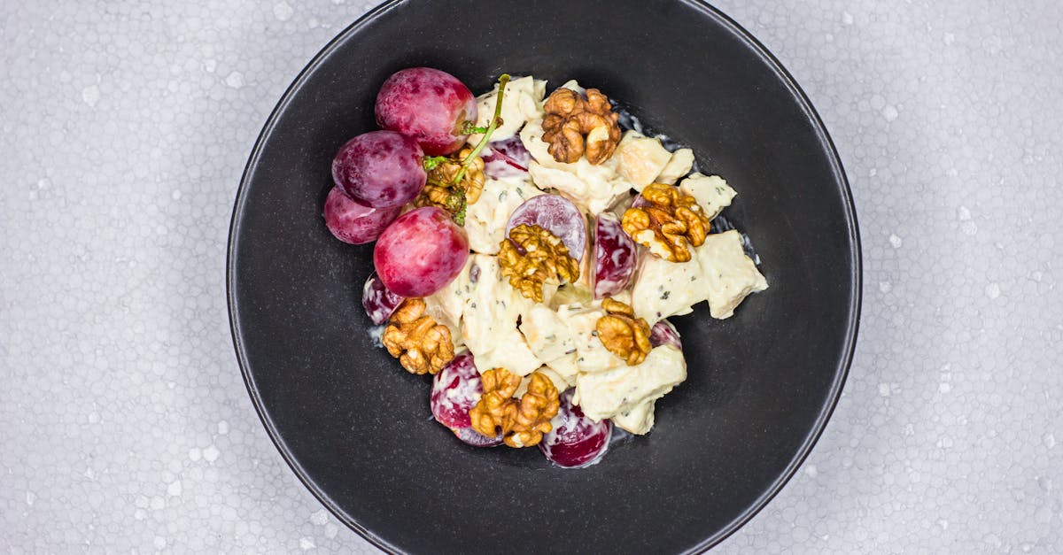 delicious waldorf salad featuring grapes apples and walnuts in a sleek black bowl