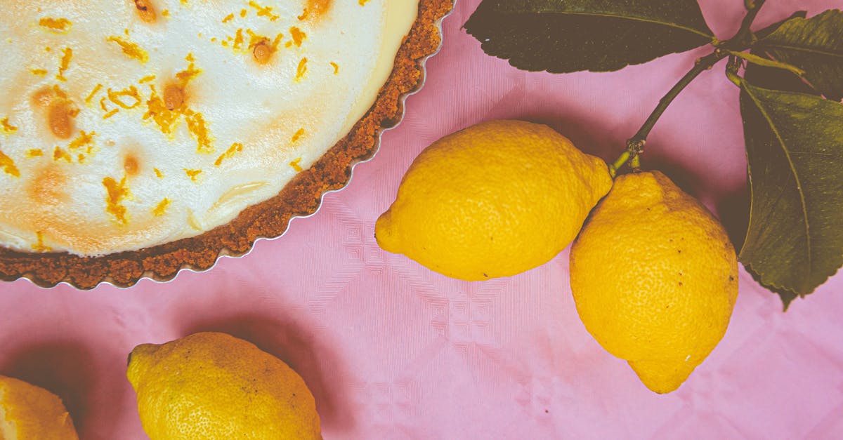 elegant lemon meringue pie with zest accents and fresh lemons on a vibrant pink background