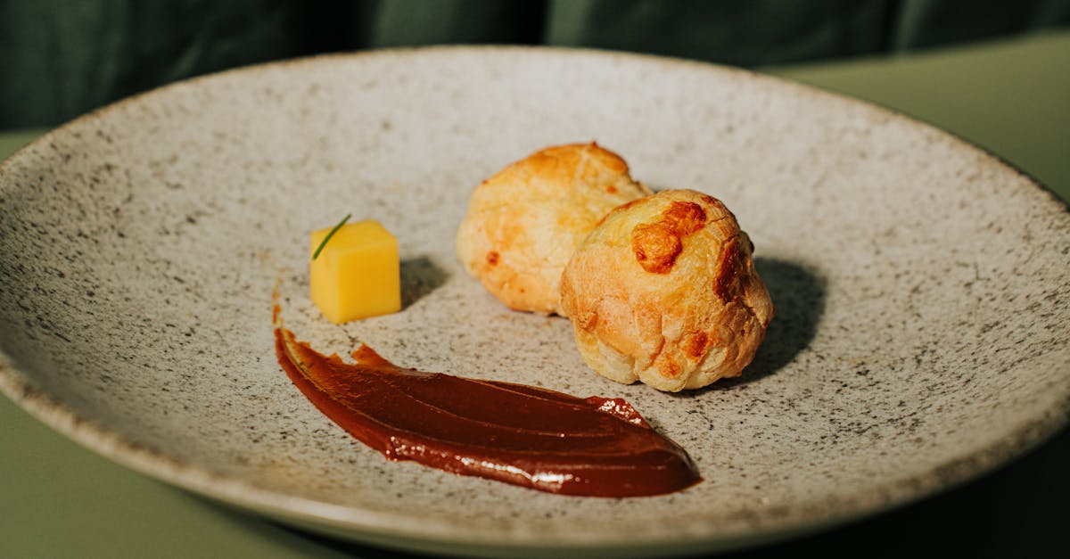 elegant presentation of gougeres with sauce on a speckled plate highlighting gourmet cuisine