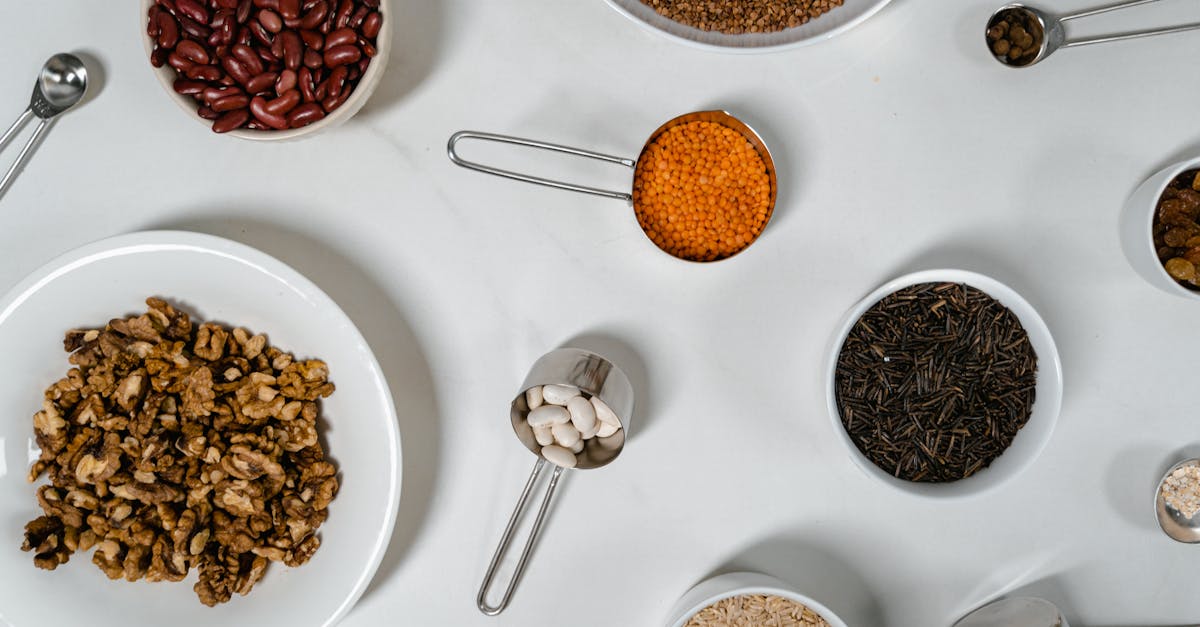 flat lay of assorted grains seeds and nuts in bowls and cups on a white surface 1