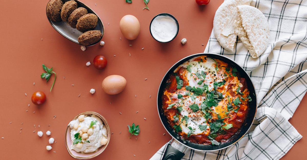 flat lay of middle eastern breakfast featuring shakshuka falafel pita and hummus