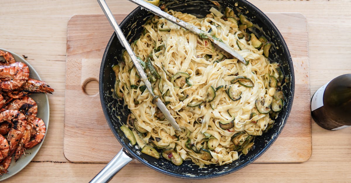 flavorful pasta with creamy zucchini and grilled shrimp on a rustic wooden board