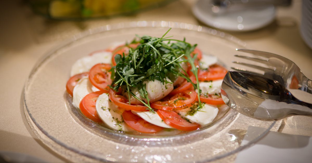fresh caprese salad with mozzarella tomatoes and arugula on a glass plate