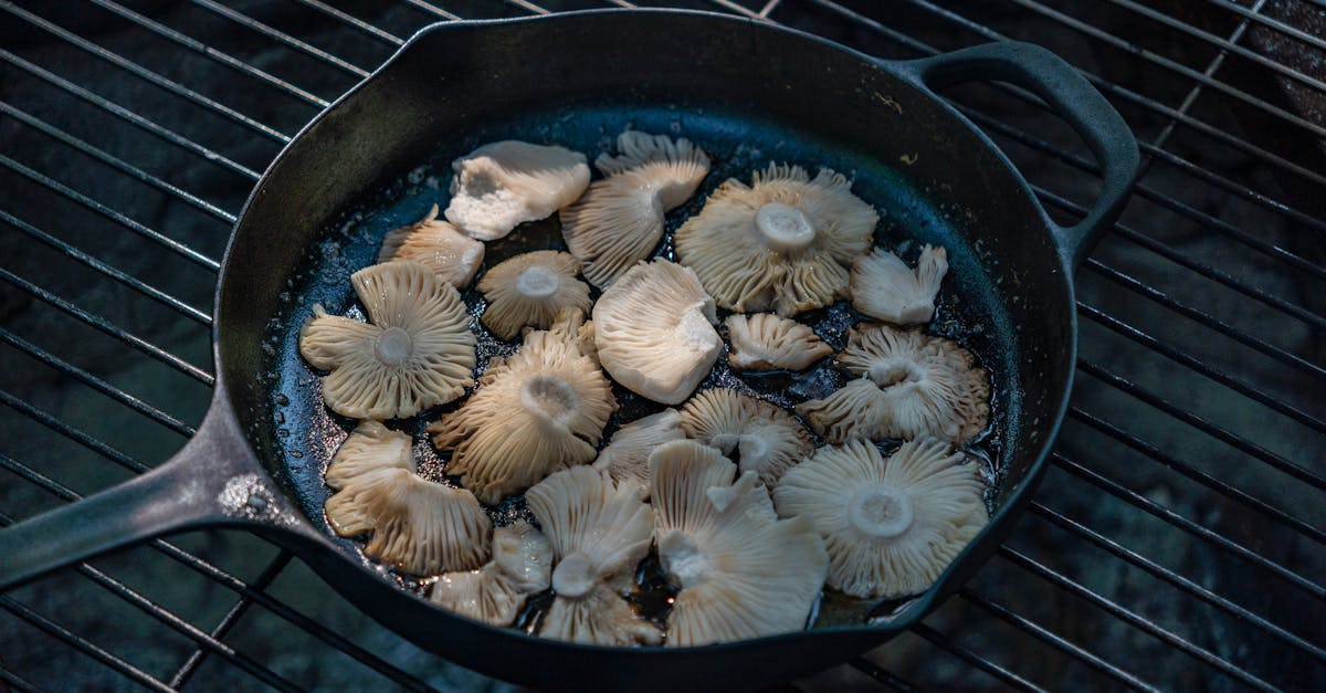 fresh mushrooms cooking on a black skillet enhancing the grilled cuisine