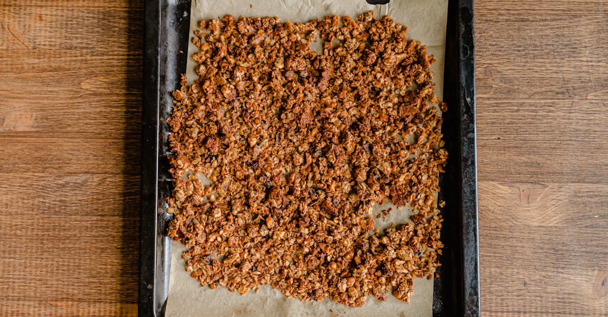 freshly baked granola cooling on a baking tray lined with parchment paper