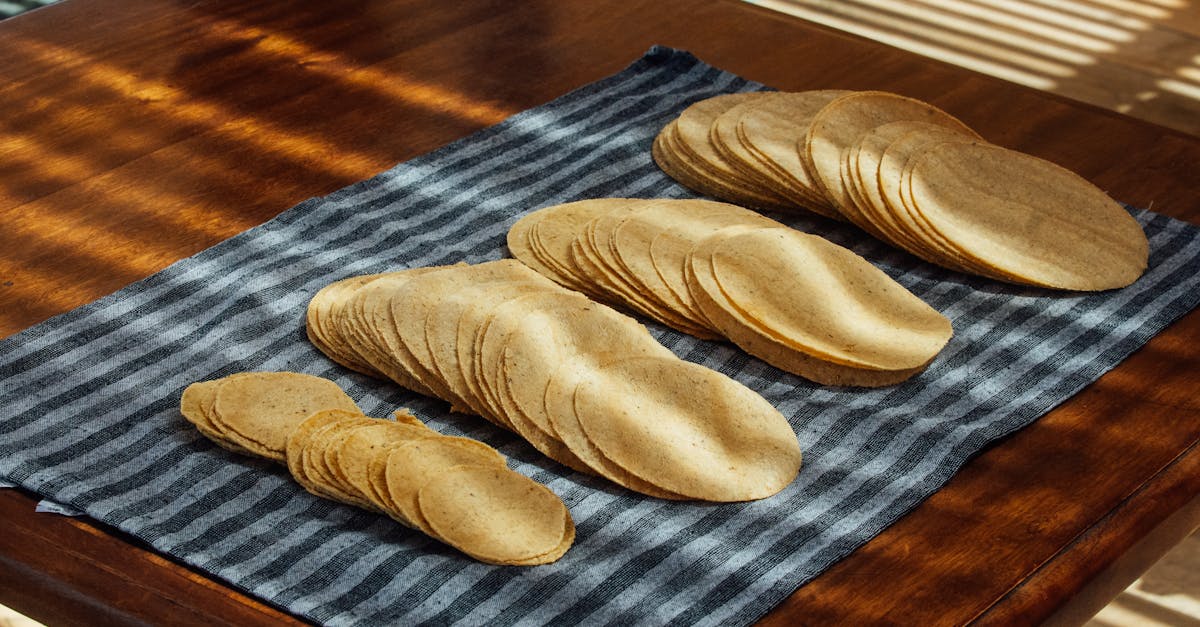freshly prepared corn tortillas arranged on a striped cloth in sunlight 1