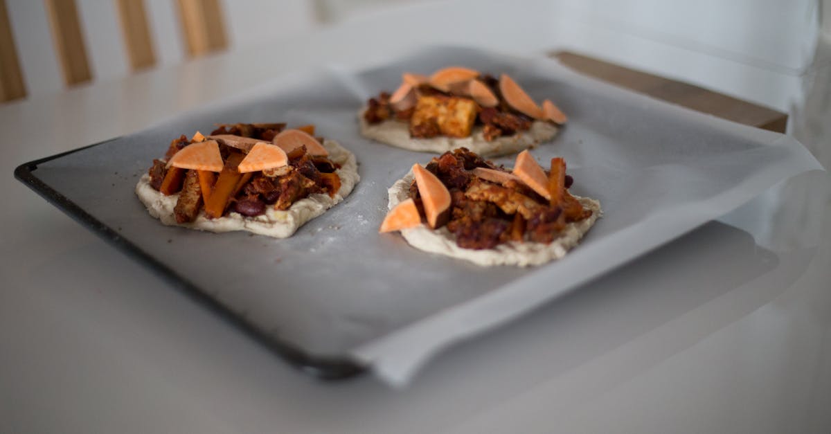 freshly prepared mini pizzas with toppings on a baking tray ready to bake
