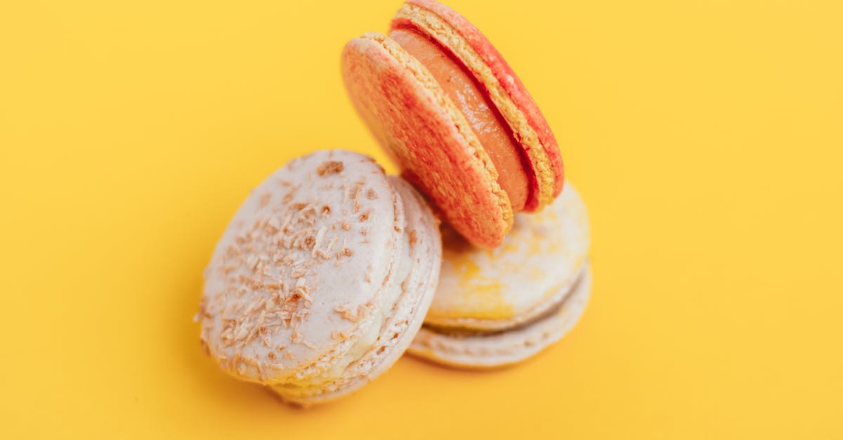 from above of delicious little homemade macaroons placed on bright yellow background of studio