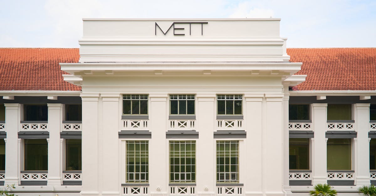front view of a colonial style building with mett signage and red tiled roof