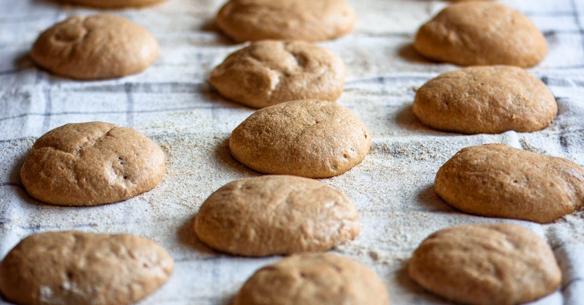 golden brown freshly baked whole wheat bread rolls cooling on a linen cloth