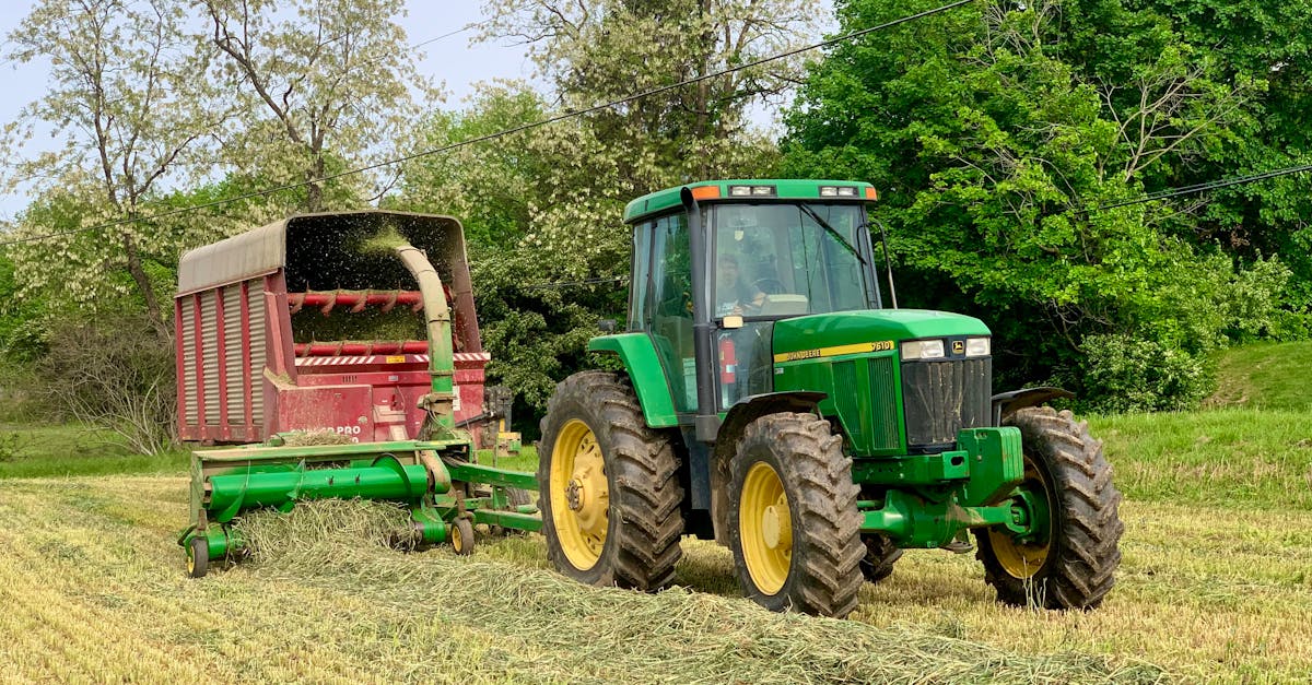 green tractor with hay wagon harvesting in lancaster pa during spring