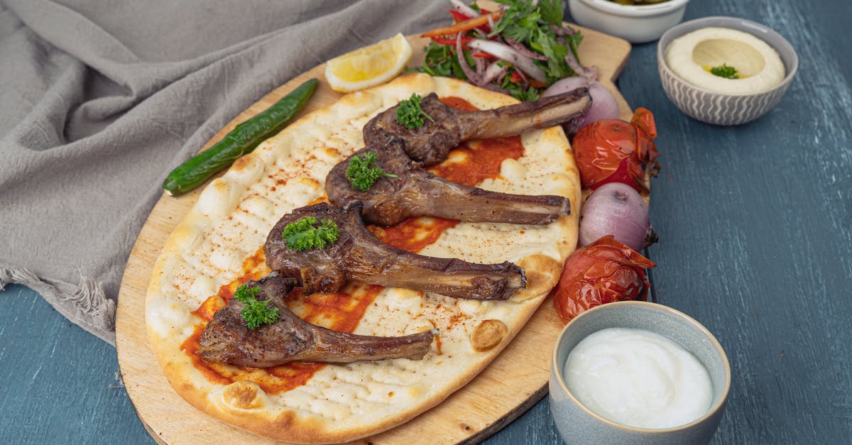 grilled lamb chops served on flatbread with side dishes ideal for middle eastern cuisine lovers