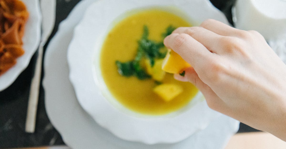hand squeezing lemon over lentil soup enhancing flavor in traditional turkish setting 2
