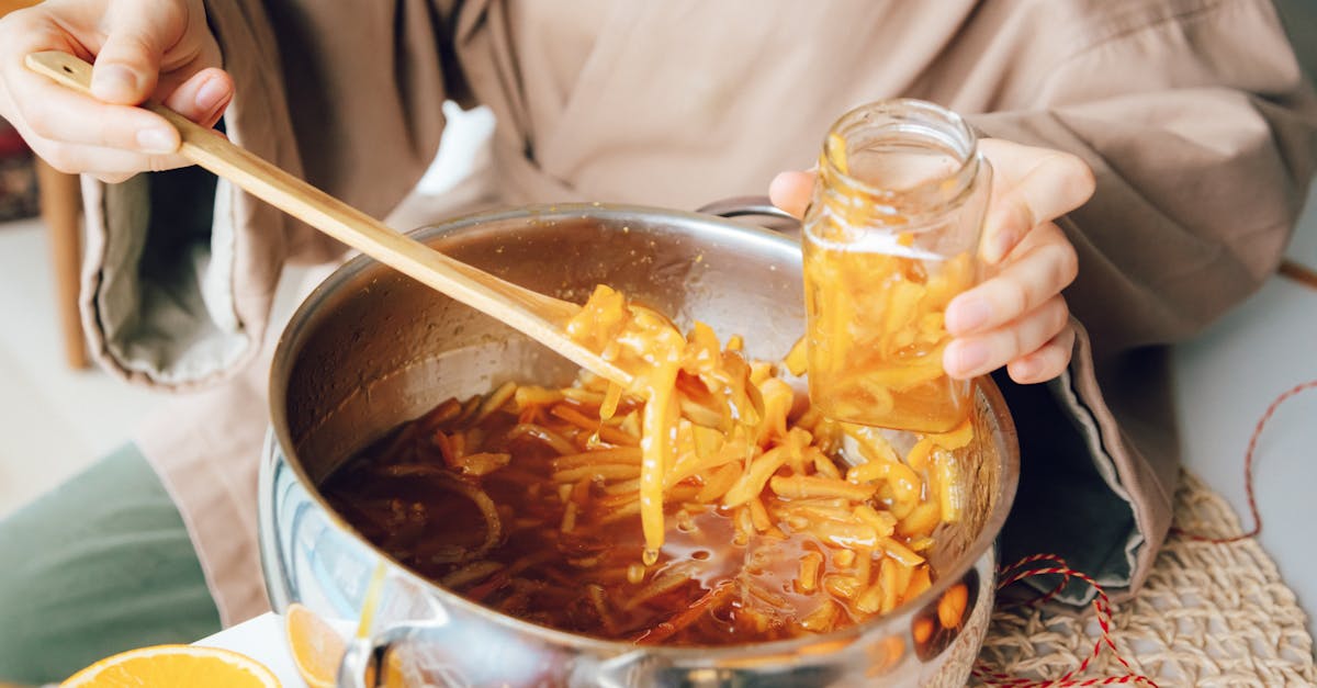 hands preparing homemade citrus marmalade in a kitchen scene with fresh oranges 3