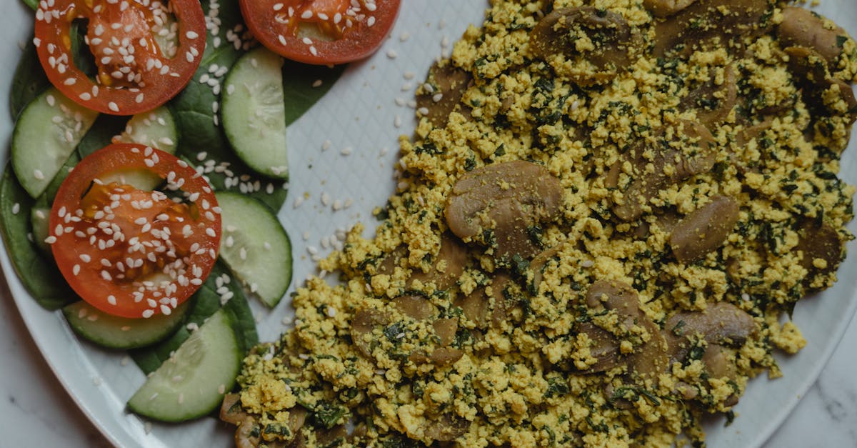 healthy vegan meal with tofu scramble cucumbers and tomatoes on a marble surface