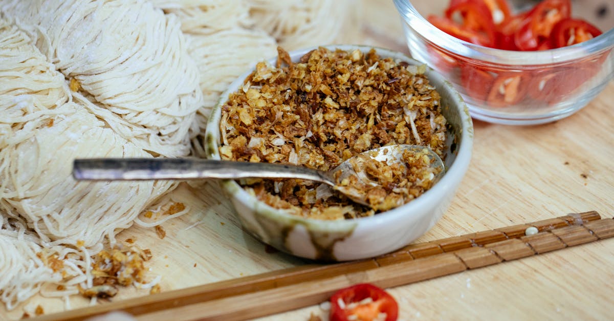 high angle shot of noodles with crispy garlic topping and fresh chili slices on a cutting board 1