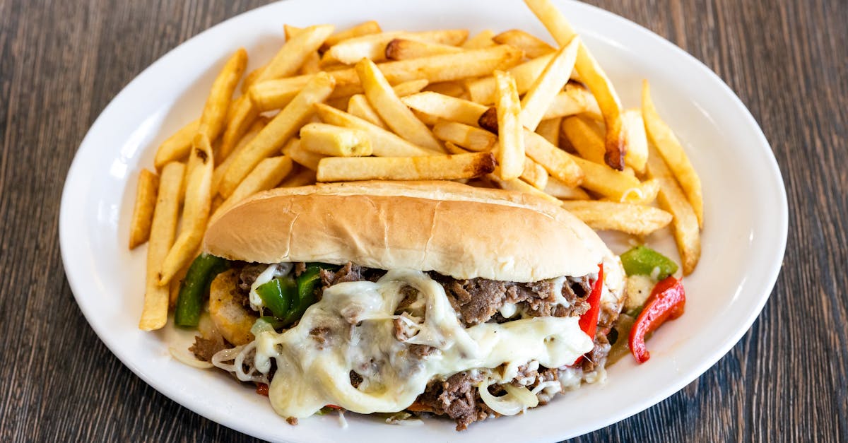 mouth watering philly cheesesteak with melted cheese and french fries