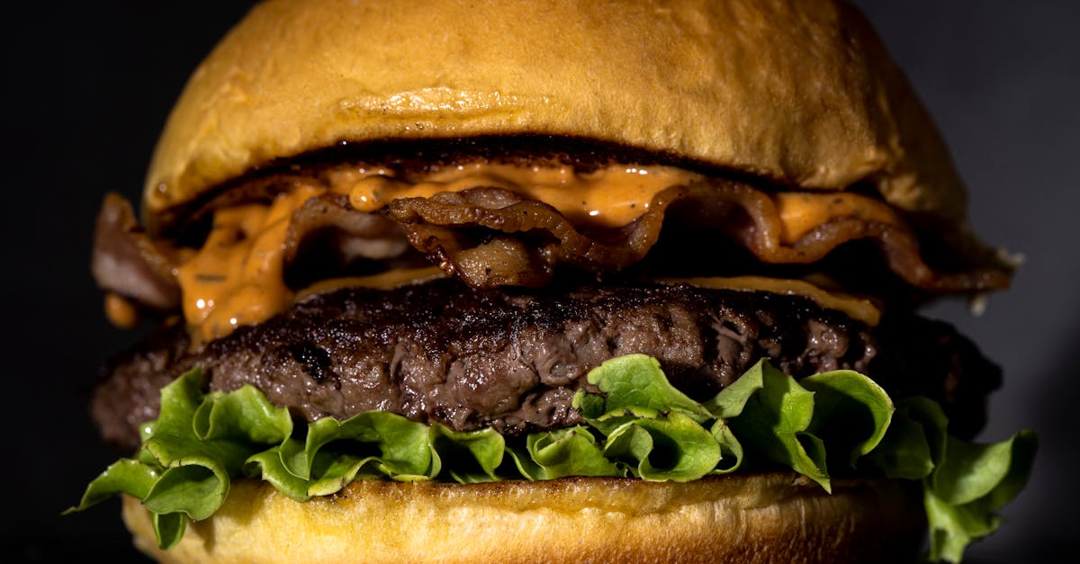 mouthwatering bacon cheeseburger with lettuce and sauce on a toasted bun