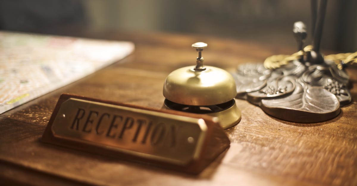 old fashioned golden service bell and reception sign placed on wooden counter of hotel with retro in