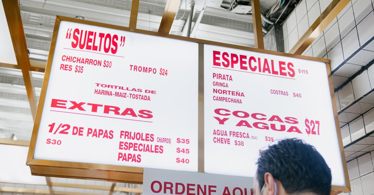 overhead illuminated menu sign with various food options in a mexican restaurant setting