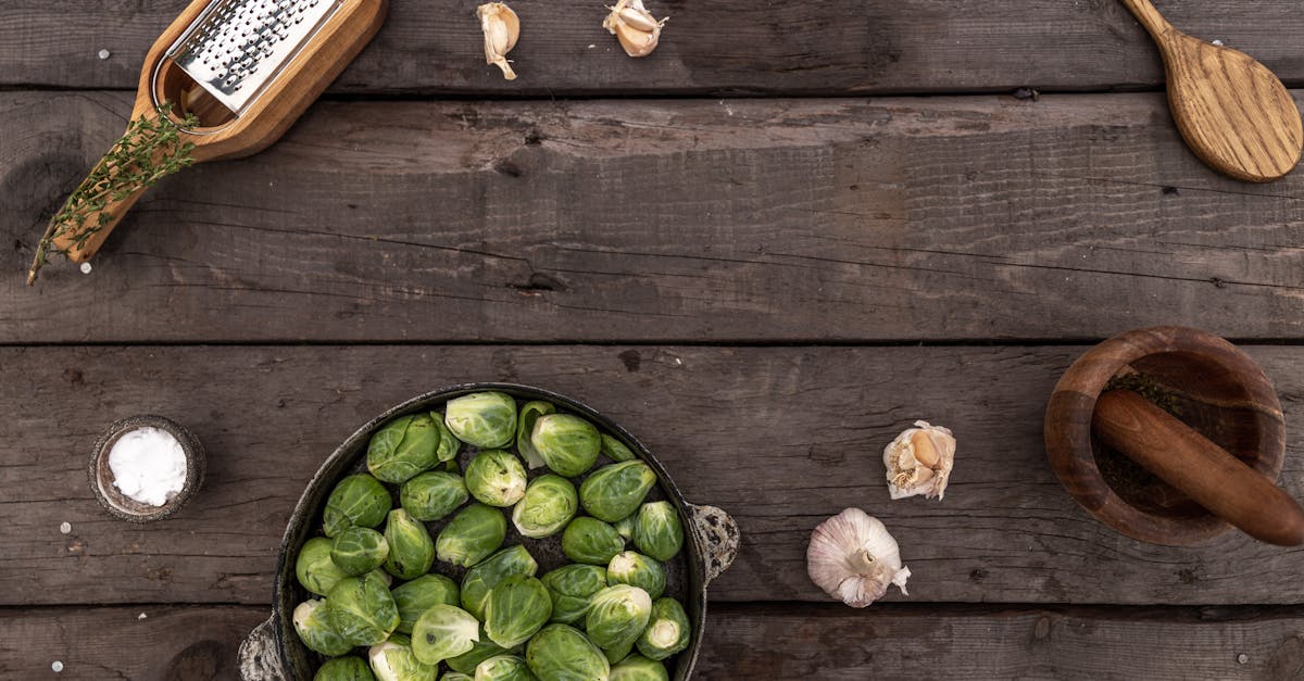 overhead image of brussels sprouts and garlic on a rustic wooden surface with kitchen tools 1