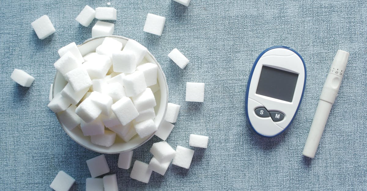 overhead shot of a glucometer and sugar cubes representing diabetes management and sugar intake