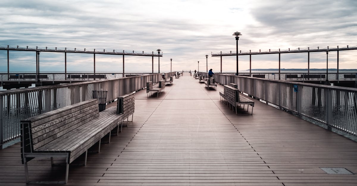 peaceful view of coney island pier with benches and a cloudy sky perfect for