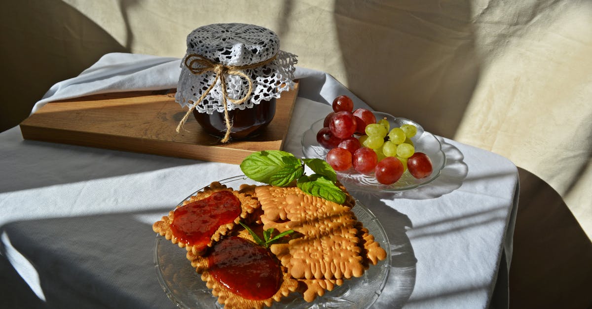 plate of biscuits with fruit jam and grapes creates a perfect breakfast scene