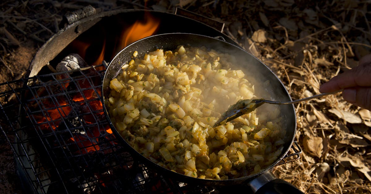 rustic hash browns cooking on a campfire grill outdoors emitting steam and aroma