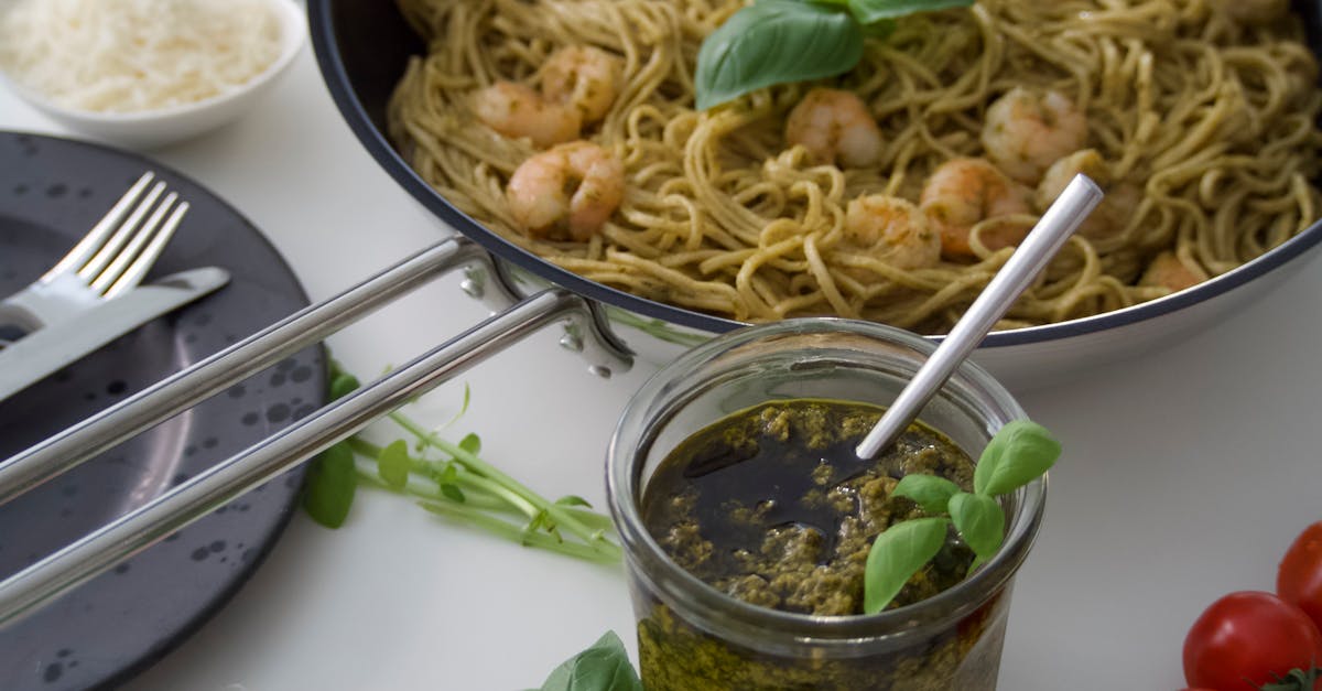 savor the taste of shrimp pesto pasta garnished with fresh basil and cherry tomatoes