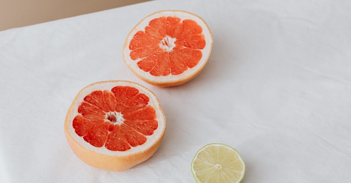 sliced grapefruit and lime displayed on white cloth for healthy food concept