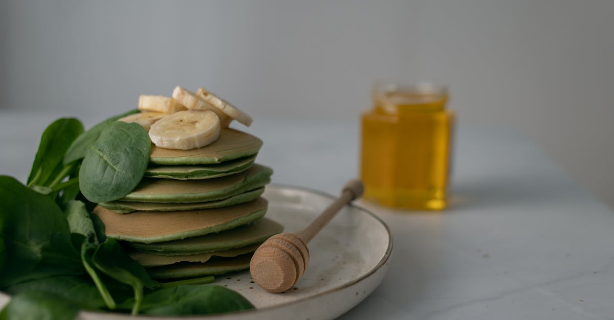 stack of spinach pancakes with banana slices and honey perfect for a nutritious breakfast