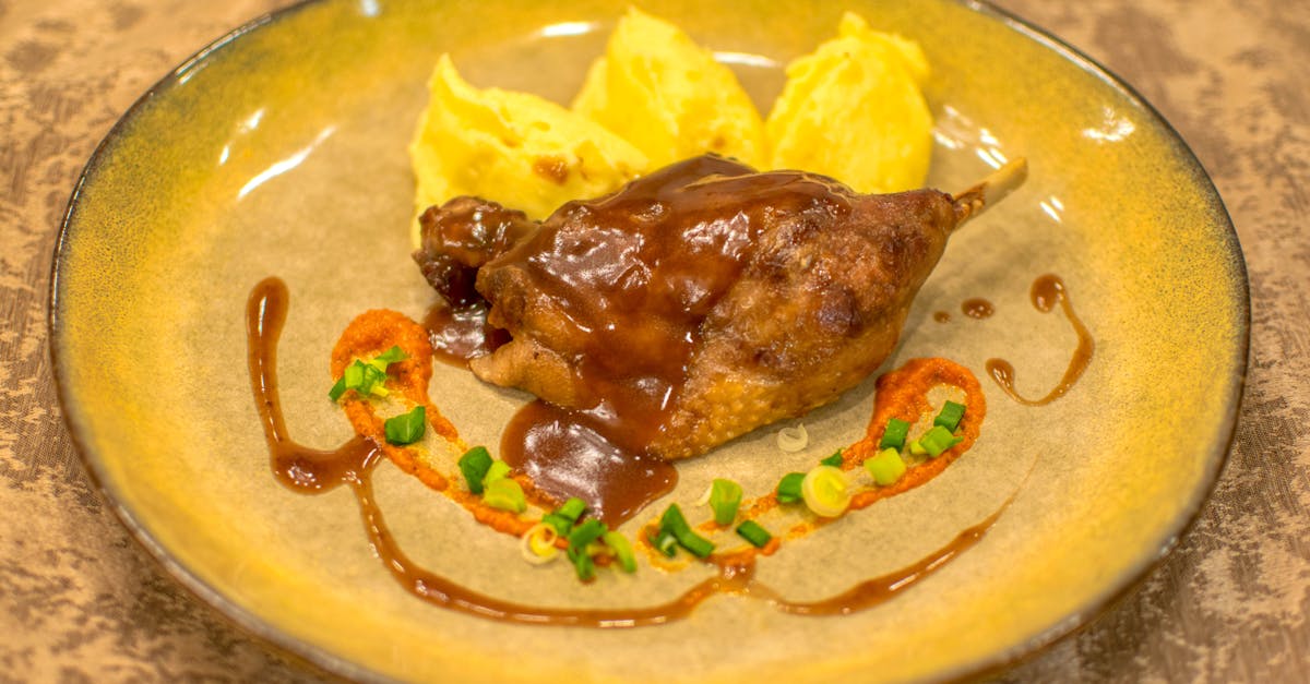 succulent duck leg with rich sauce and creamy mashed potatoes on a rustic plate