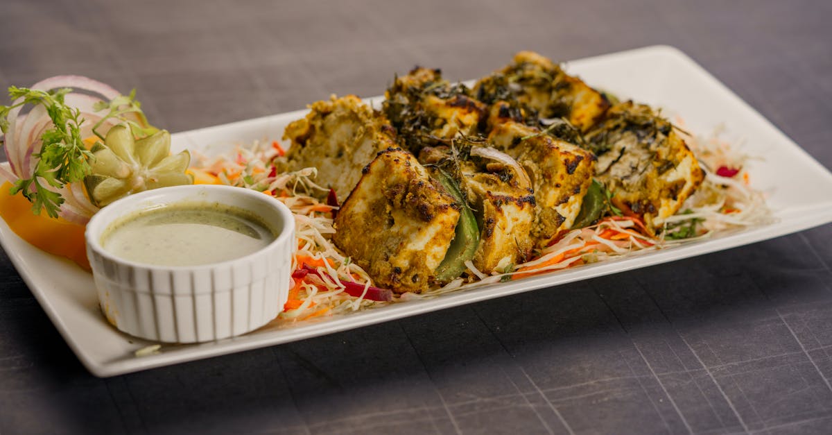 succulent herb crusted paneer tikka served with chutney and salad on a stylish plate