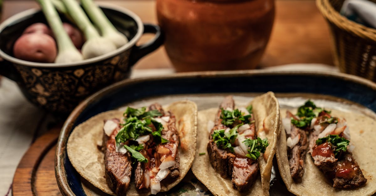 three mouth watering steak tacos topped with cilantro and onions on a rustic table setting 3