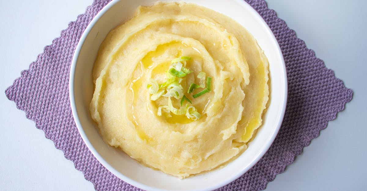 top down view of creamy mashed potatoes garnished with scallion in a white bowl 4