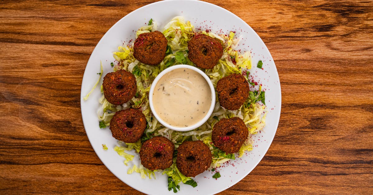 top view of a falafel salad with creamy tahini on a wooden table