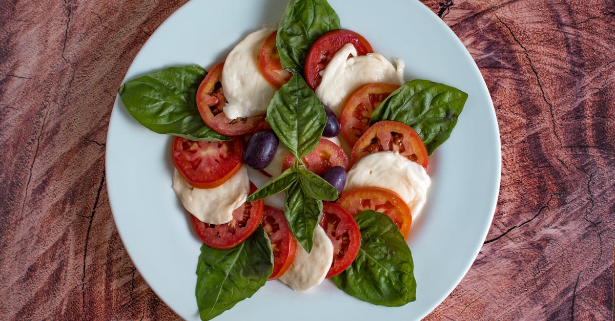 Home top view of a fresh caprese salad featuring tomatoes mozzarella basil and olives