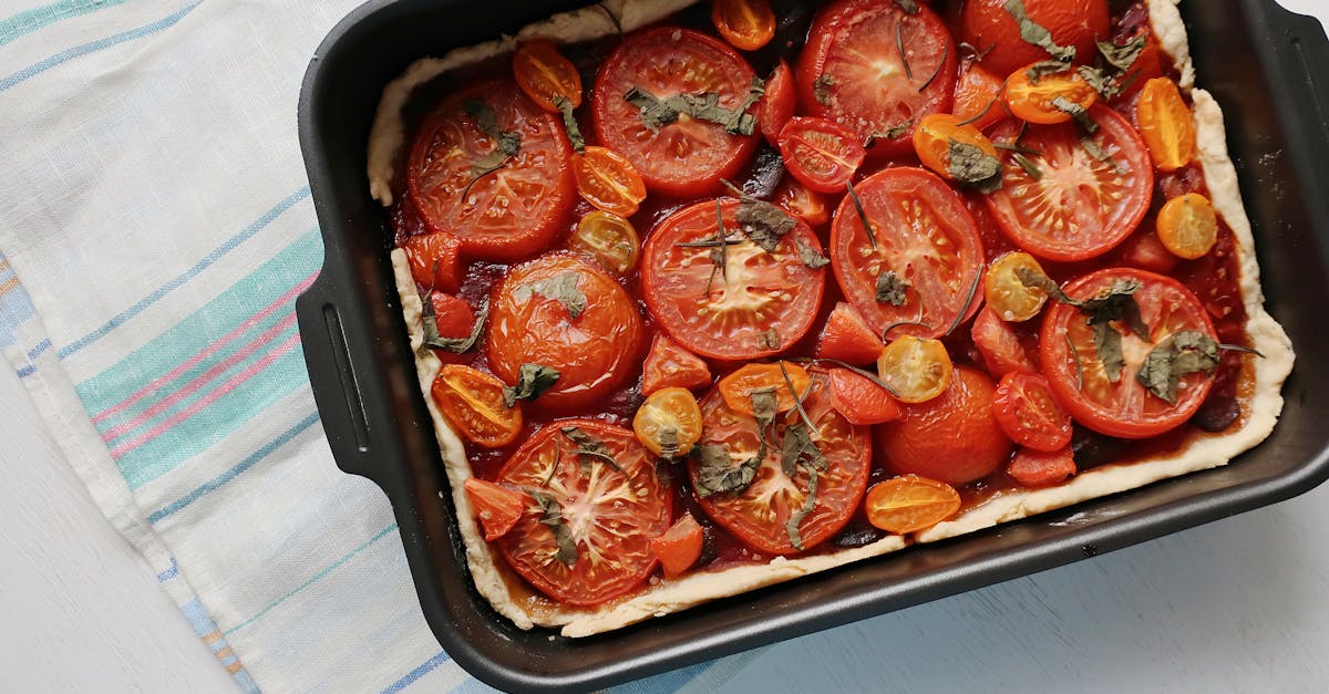 top view of a freshly baked tomato tart with herbs and cherry tomatoes