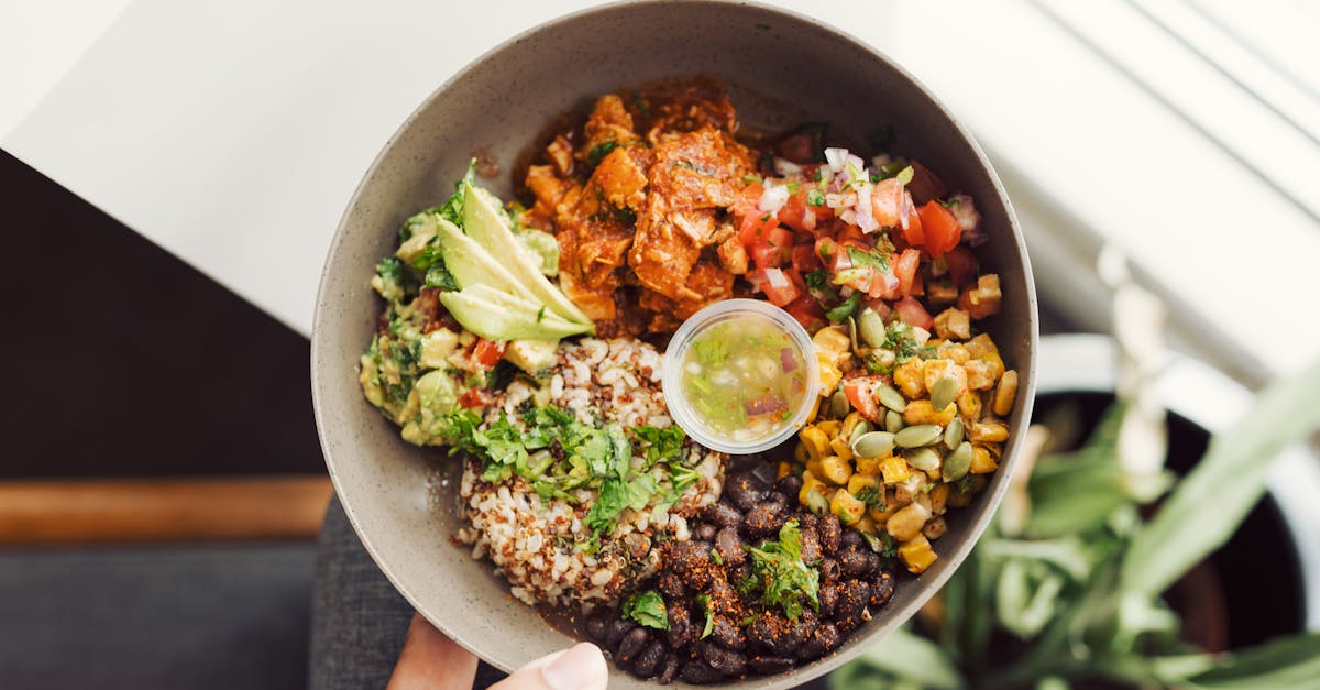 Home top view of a vibrant vegan buddha bowl with quinoa avocado and fresh salsa in hand 2