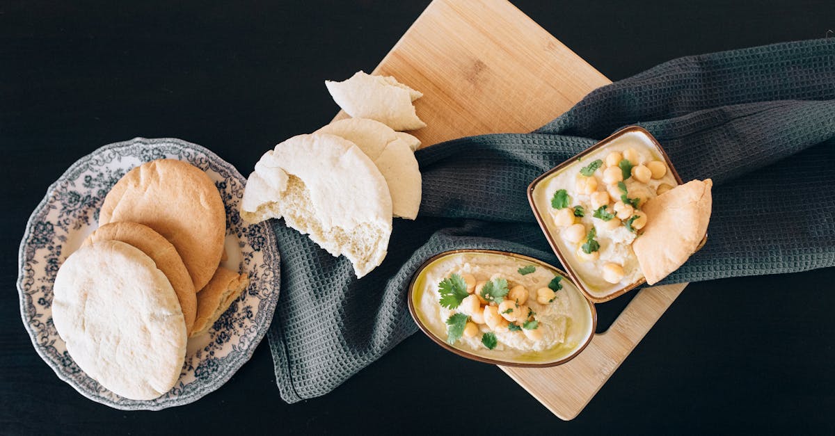 top view of delicious creamy hummus with pita bread on a wooden board