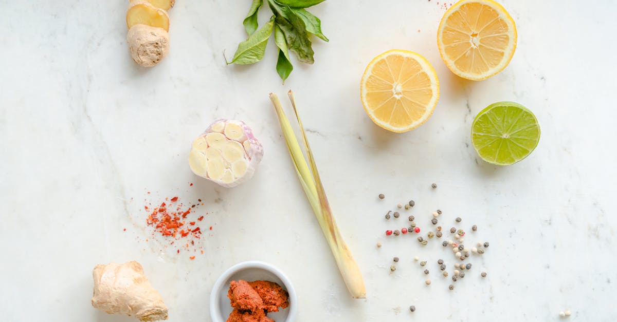 top view of fresh ingredients including ginger garlic lemon and spices on a white background 2