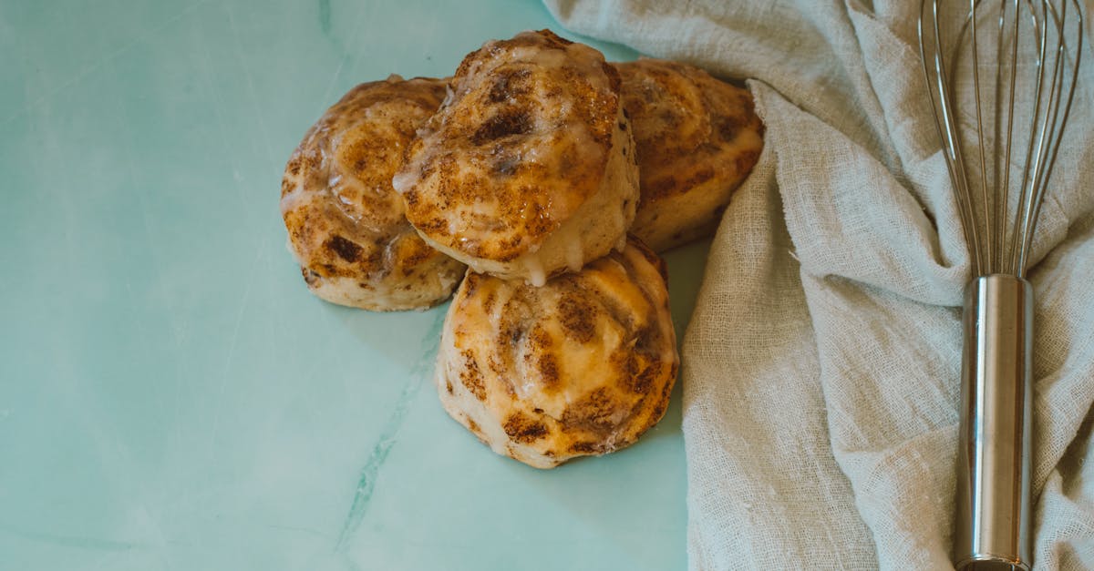 top view of homemade cinnamon rolls with a whisk on a cloth background perfect for baking and food 3