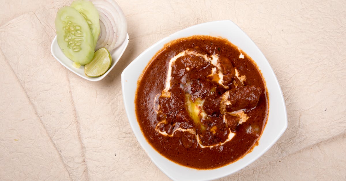top view of indian kidney bean curry with cucumber onions and lime on the side