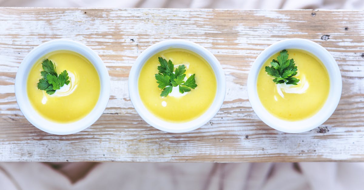 top view of three bowls of vibrant leek and potato soup garnished with fresh parsley