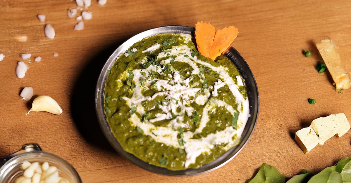 top view of traditional indian palak paneer garnished with cream and vegetables