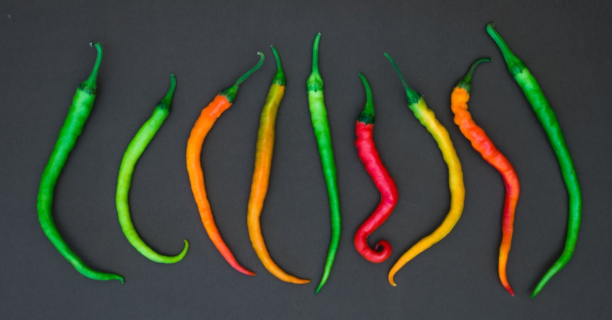 top view of vibrant chili peppers arranged on a dark black background