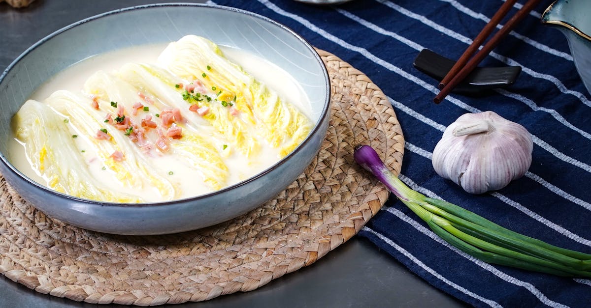 traditional asian cuisine featuring a cabbage dish in a creamy broth garnished with garlic and chiv