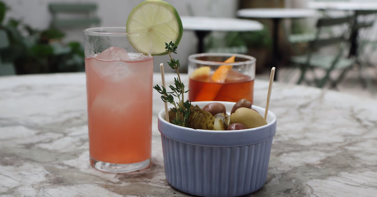 two refreshing cocktails and a bowl of snacks on a marble table perfect for a casual outdoor settin