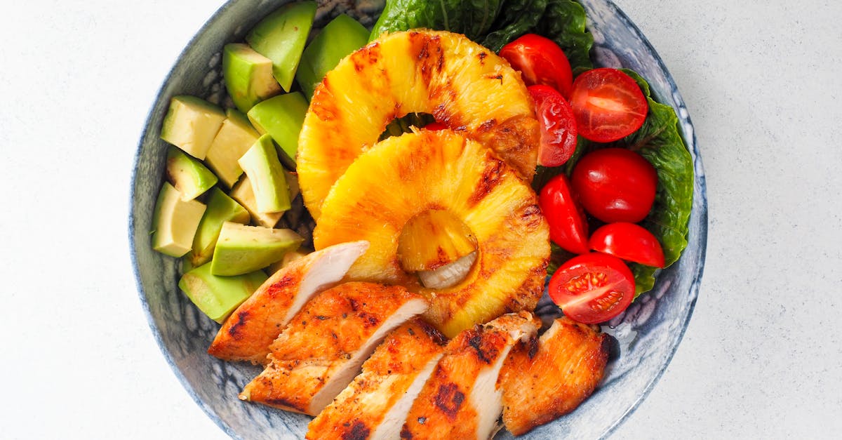 vibrant top view of a salad bowl with grilled chicken pineapple avocado and cherry tomatoes 1